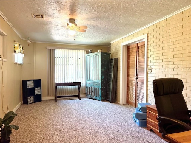 office space with brick wall, carpet, ceiling fan, crown molding, and a textured ceiling