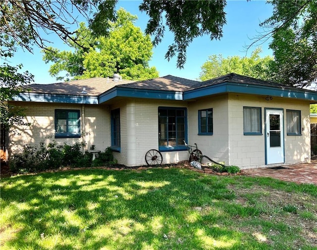 rear view of property with a lawn