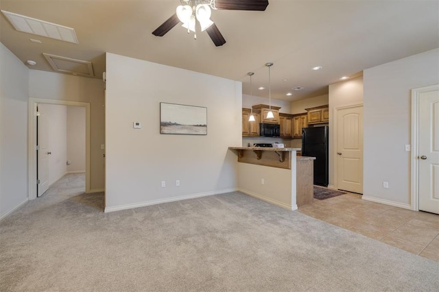 kitchen with kitchen peninsula, light colored carpet, a breakfast bar area, and black appliances