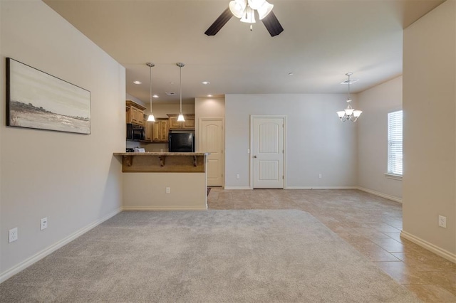 unfurnished living room featuring ceiling fan with notable chandelier and light colored carpet