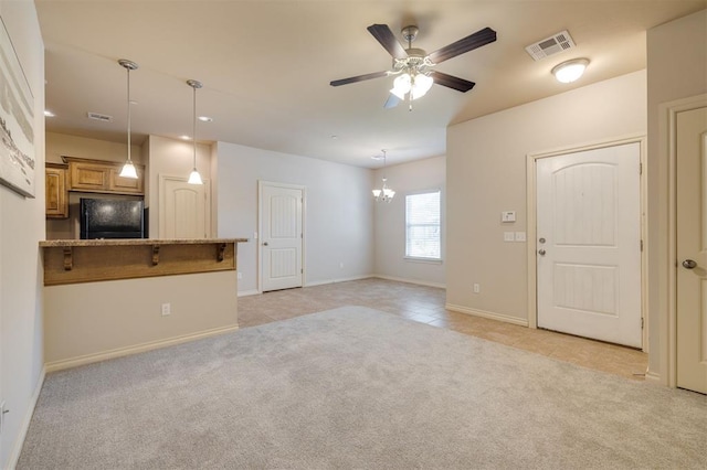 unfurnished living room with light colored carpet and ceiling fan with notable chandelier