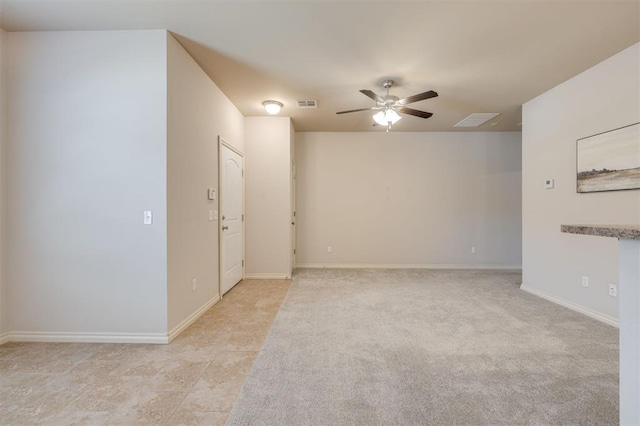 spare room featuring light colored carpet and ceiling fan