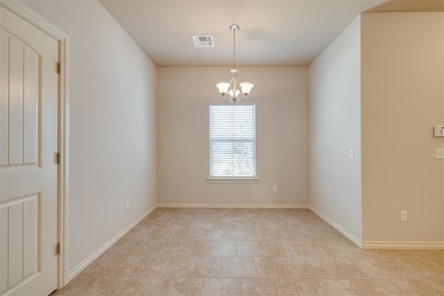 spare room featuring a chandelier