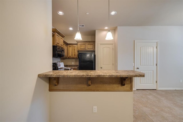 kitchen with a kitchen breakfast bar, kitchen peninsula, pendant lighting, and black appliances