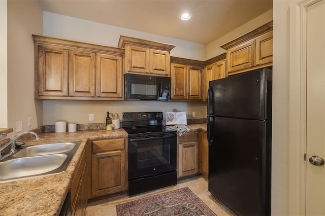 kitchen featuring black appliances, light tile patterned floors, and sink