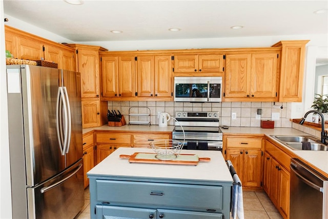 kitchen featuring light tile patterned flooring, appliances with stainless steel finishes, a center island, and sink