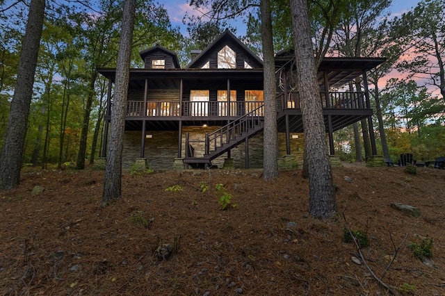 back house at dusk with a wooden deck