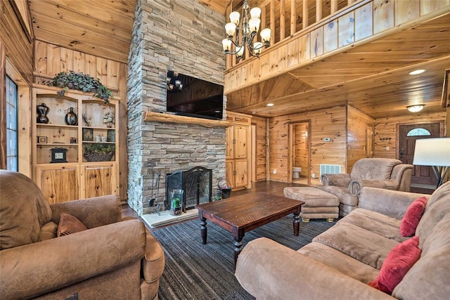 living room featuring a stone fireplace, wood walls, and a high ceiling