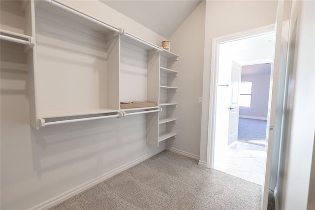 walk in closet with lofted ceiling and carpet floors