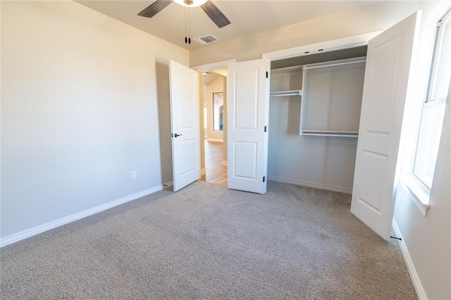 unfurnished bedroom featuring light carpet, ceiling fan, and a closet