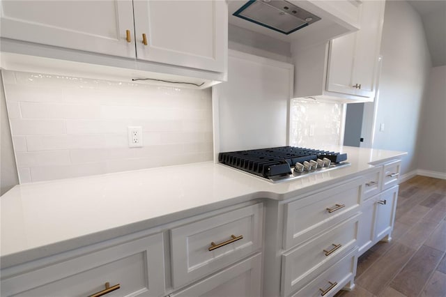 kitchen with white cabinetry, stainless steel gas cooktop, and backsplash