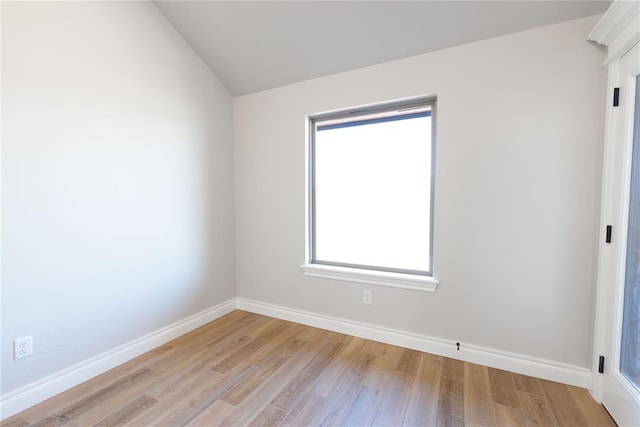 spare room with lofted ceiling and light hardwood / wood-style flooring