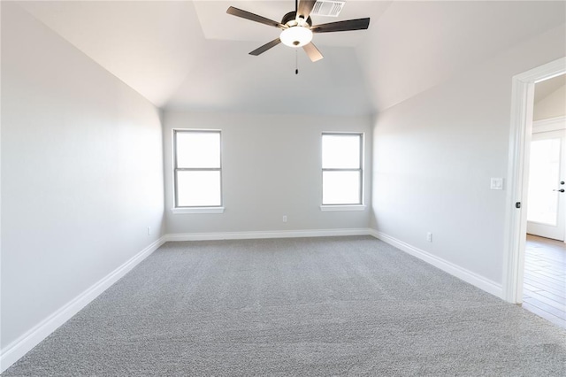 spare room featuring vaulted ceiling, plenty of natural light, carpet floors, and ceiling fan