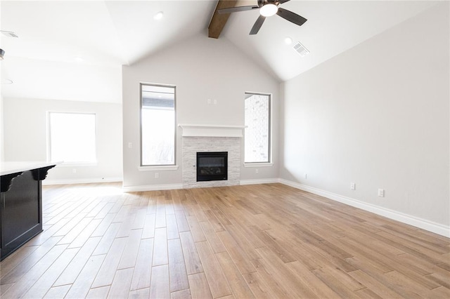 unfurnished living room featuring a wealth of natural light, visible vents, light wood-style floors, and a ceiling fan