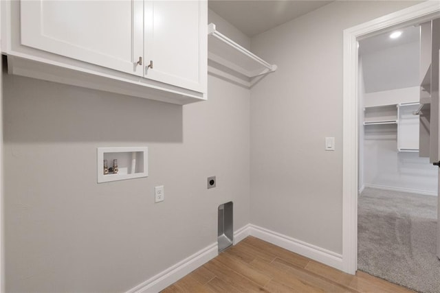 laundry room with washer hookup, baseboards, hookup for an electric dryer, light wood-type flooring, and cabinet space