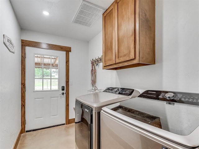 washroom featuring washer and clothes dryer and cabinets