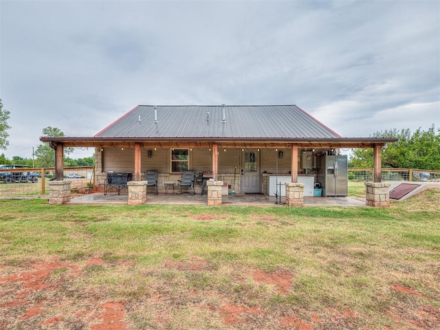 rear view of house with a lawn and a patio area