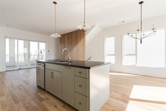 kitchen with dark countertops, an inviting chandelier, a sink, stainless steel dishwasher, and visible vents