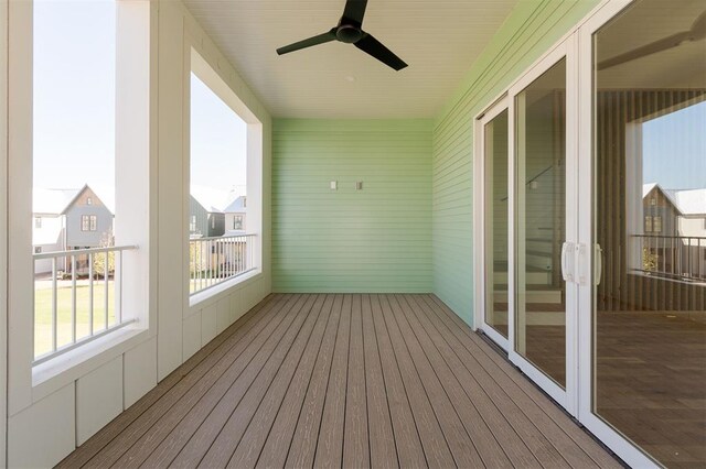 unfurnished sunroom featuring a ceiling fan