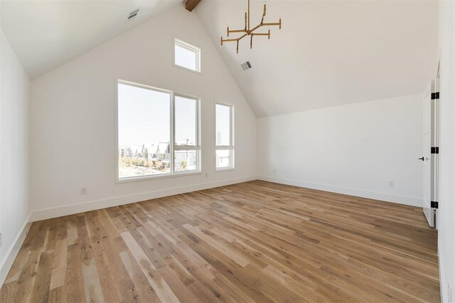 additional living space with visible vents, baseboards, light wood finished floors, and a chandelier