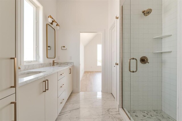 full bath featuring double vanity, a shower stall, a sink, and marble finish floor
