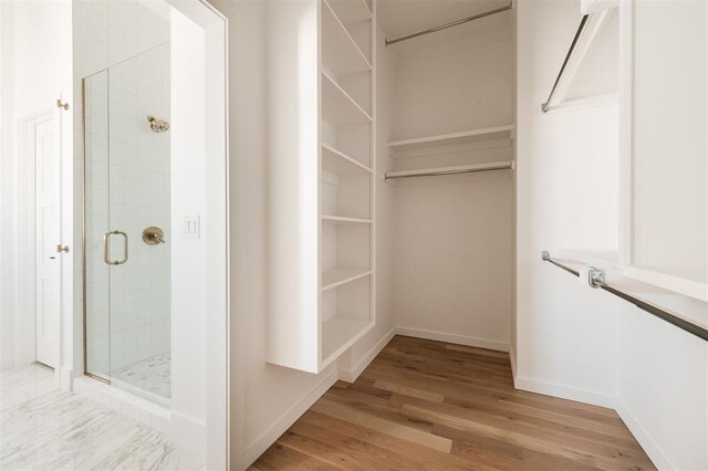 walk in closet with light wood-type flooring
