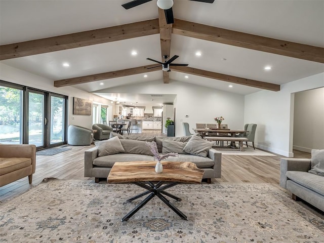 living room with vaulted ceiling with beams, ceiling fan, and light hardwood / wood-style floors