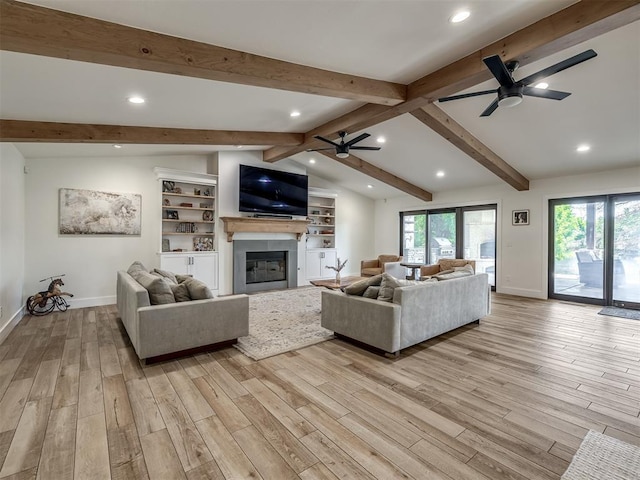 living room featuring vaulted ceiling with beams, ceiling fan, plenty of natural light, and light hardwood / wood-style flooring