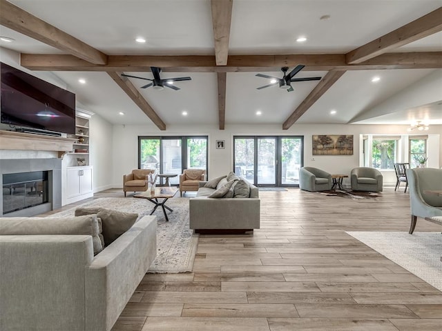 living room with vaulted ceiling with beams, ceiling fan, and light hardwood / wood-style flooring