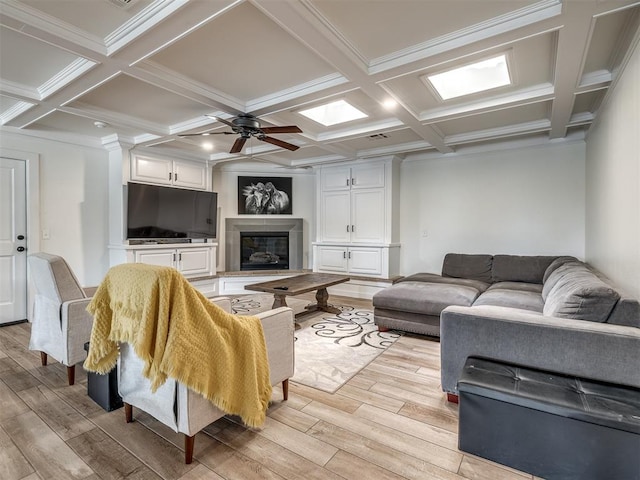 living room featuring beam ceiling, light hardwood / wood-style floors, ceiling fan, and coffered ceiling