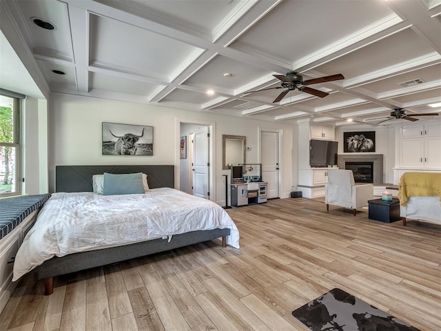 bedroom featuring beamed ceiling, light wood-type flooring, and coffered ceiling