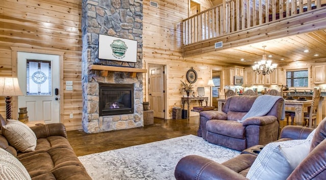 living room with wooden ceiling, a towering ceiling, a chandelier, wooden walls, and a fireplace