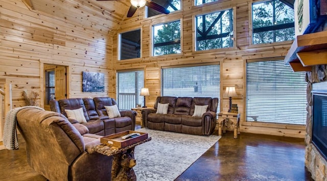 living room featuring wooden walls, high vaulted ceiling, and ceiling fan