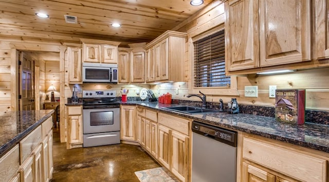 kitchen with dark stone countertops, light brown cabinetry, sink, and appliances with stainless steel finishes