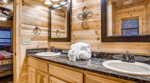 bathroom featuring vanity and wood walls