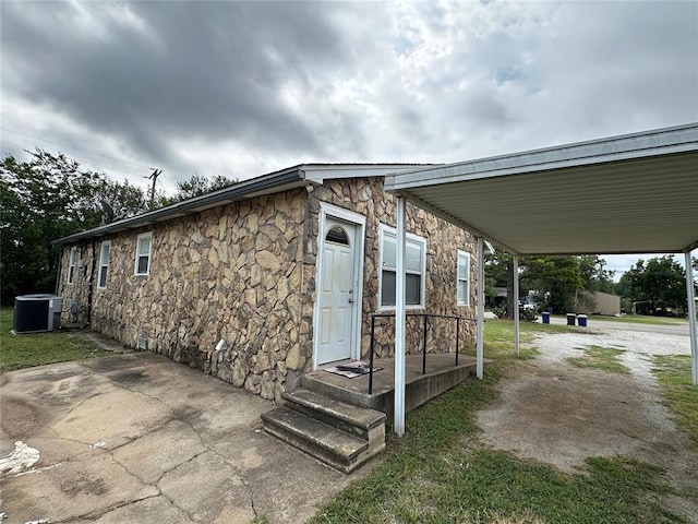 exterior space with a carport and cooling unit