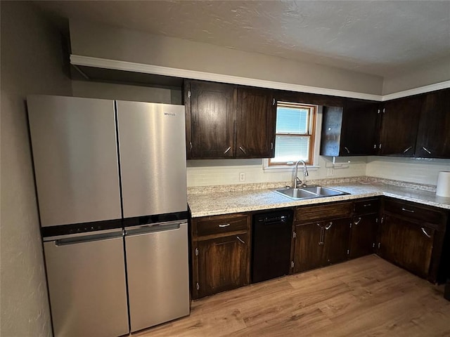 kitchen featuring stainless steel refrigerator, dark brown cabinetry, sink, black dishwasher, and light wood-type flooring