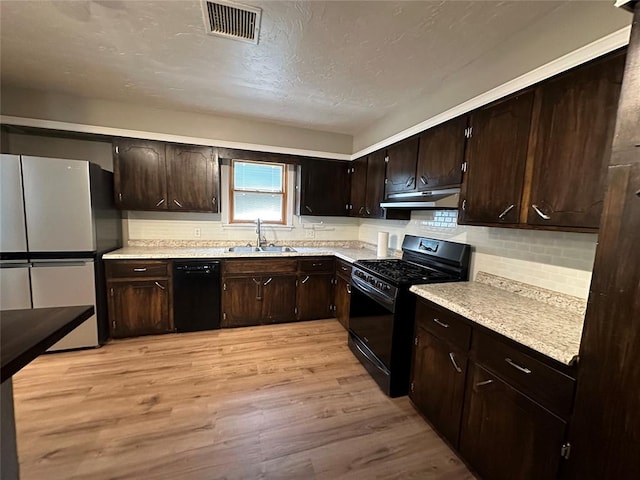 kitchen with black appliances, sink, light hardwood / wood-style flooring, a textured ceiling, and dark brown cabinets