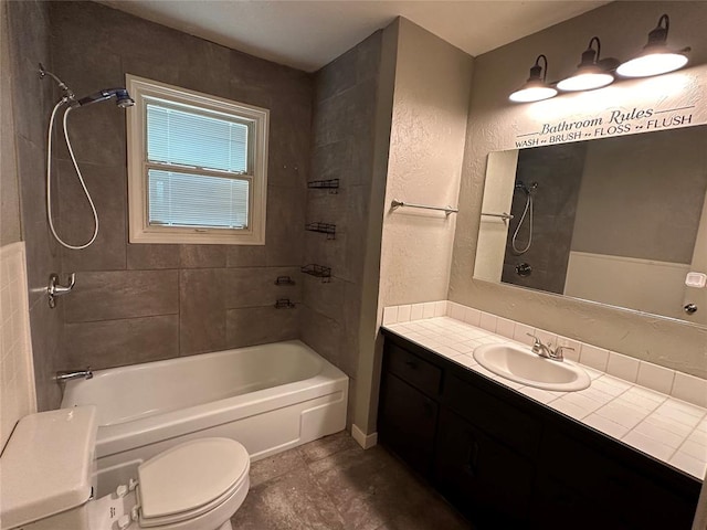 full bathroom featuring tile patterned floors, vanity, toilet, and tiled shower / bath