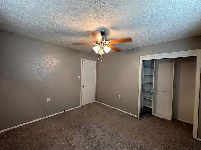 unfurnished bedroom featuring dark colored carpet, ceiling fan, a textured ceiling, and a closet