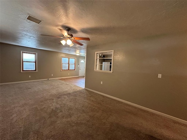 unfurnished room with ceiling fan, carpet, and a textured ceiling