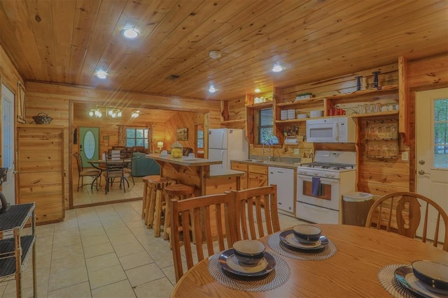 tiled dining area featuring plenty of natural light and wooden walls