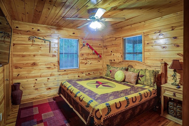 bedroom with ceiling fan, dark hardwood / wood-style floors, wood ceiling, and wood walls