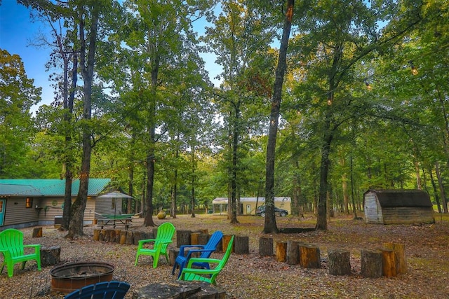 view of yard featuring a storage unit and an outdoor fire pit