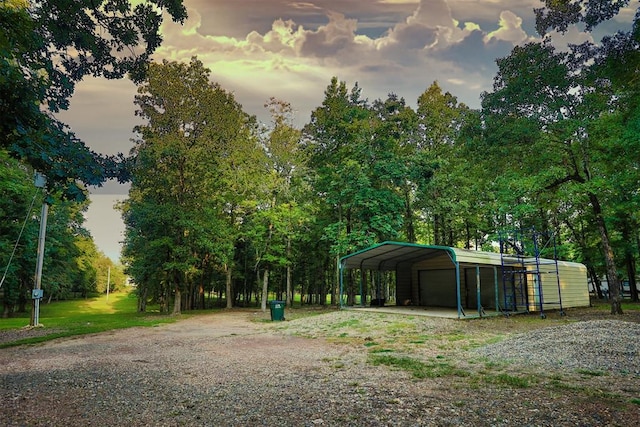 yard at dusk featuring a carport