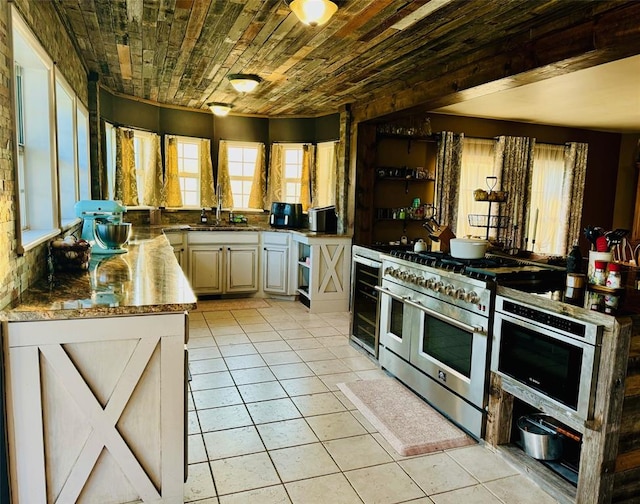 kitchen featuring sink, light tile patterned flooring, range with two ovens, and wooden ceiling