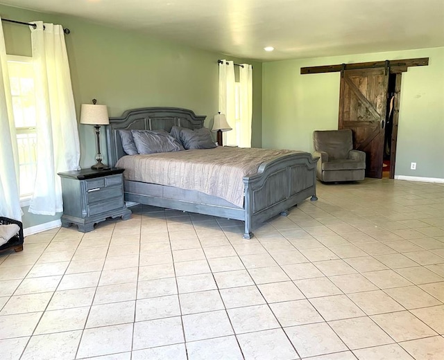 bedroom featuring a barn door and light tile patterned floors