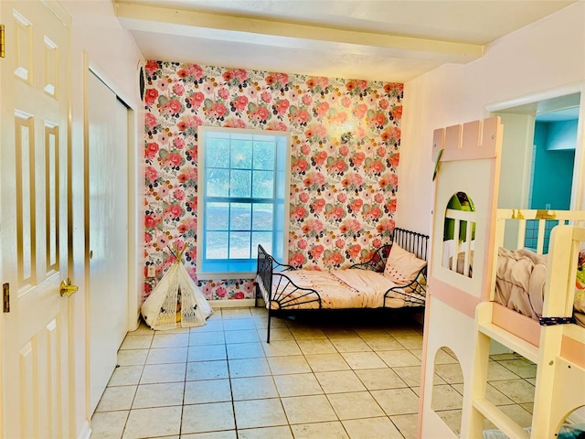 bedroom with light tile patterned floors and beamed ceiling