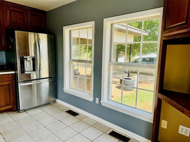 kitchen featuring stainless steel fridge with ice dispenser and light tile patterned floors