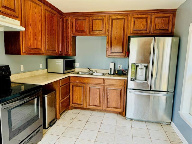 kitchen with appliances with stainless steel finishes, light tile patterned flooring, and sink